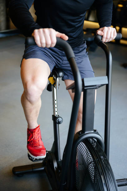 istock Vertical image of Muscular man using exercising bicycle 1352503142