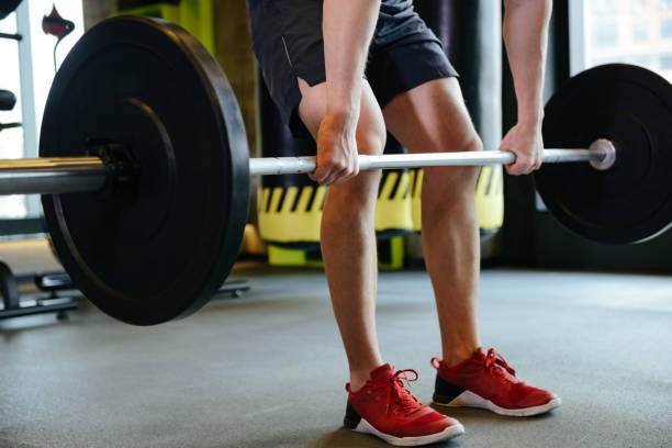 istock Cropped image of Athletic man doing exercise with barbell 1352503629