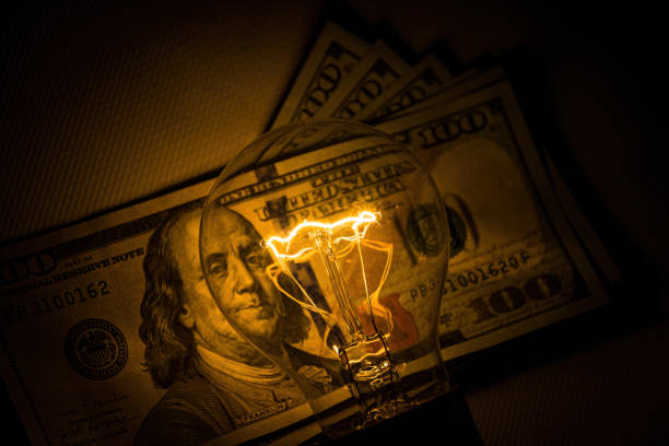 istock Rising electricity prices. Old light bulb and dollar bills 1352504318