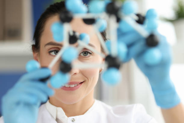 istock Woman scientist looks at dna layout closeup 1352506465