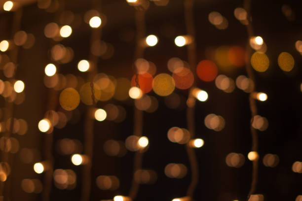 istock Abstract bokeh lights. Defocused shining yellow light leaks on dark background. New year, christmas garlands flecks. 1352508891