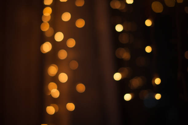 istock Abstract bokeh lights. Defocused shining yellow light leaks on dark background. New year, christmas garlands flecks. 1352508894