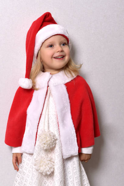 istock A girl in a Santa hat and a red cape 1352509149