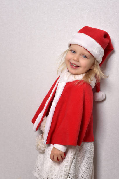 istock A girl in a Santa hat and a red cape 1352509151