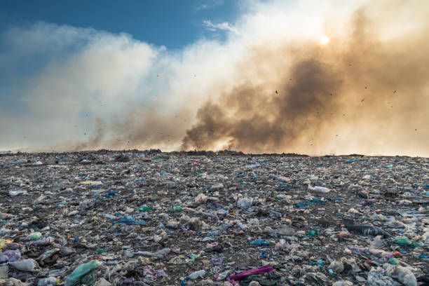 discarica con cumuli di spazzatura in fiamme. concetto di inquinamento ambientale - landfill foto e immagini stock