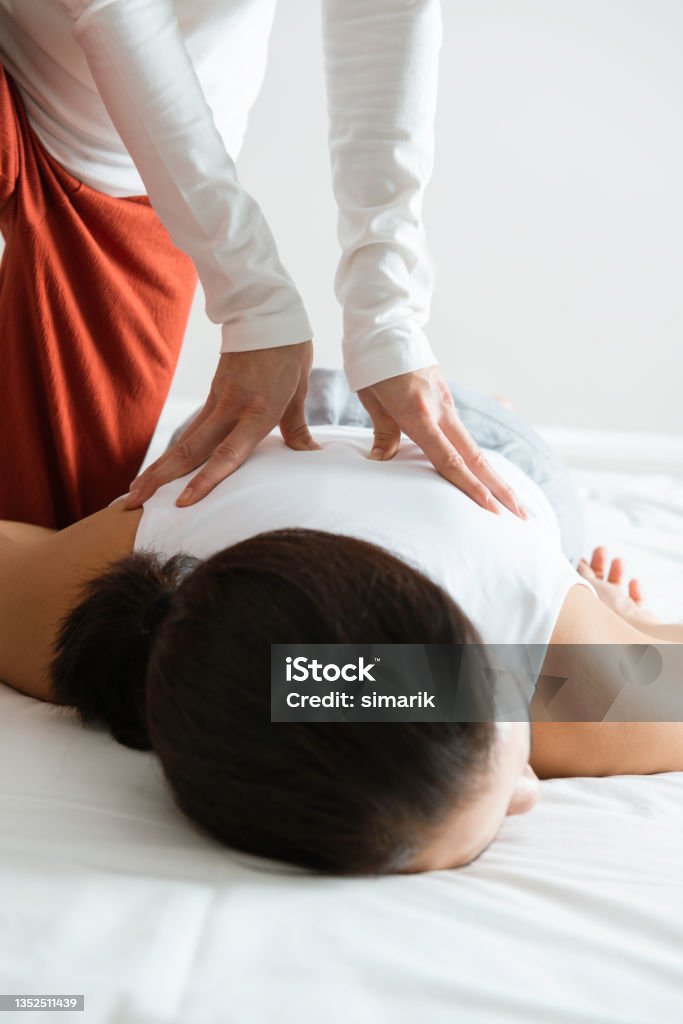 Massage Woman who is having a shiatsu massage on her back. Massaging Stock Photo