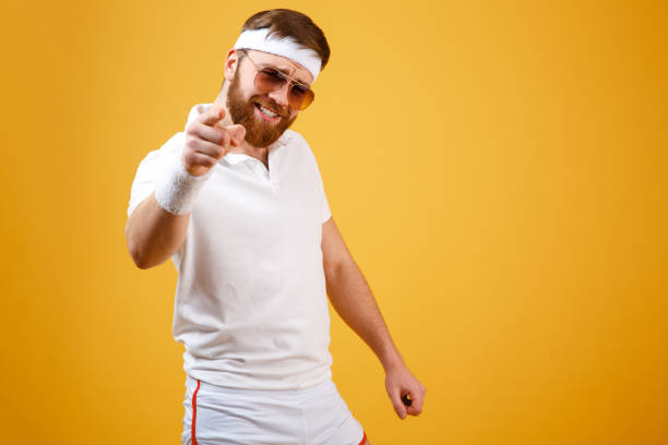 istock Cool sportsman in sunglasses pointing at camera 1352511593