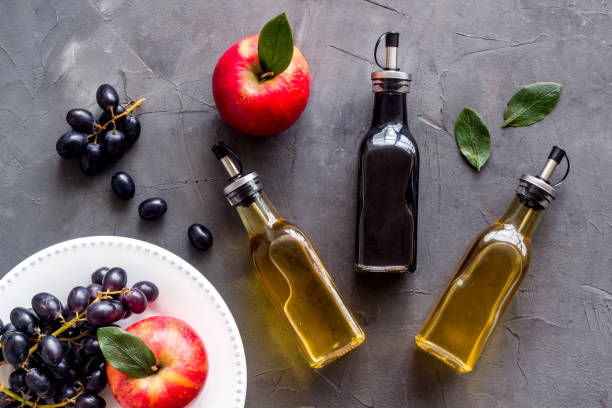 Apple cider and balsamic vinegar in bottles with grapes and red apples stock photo