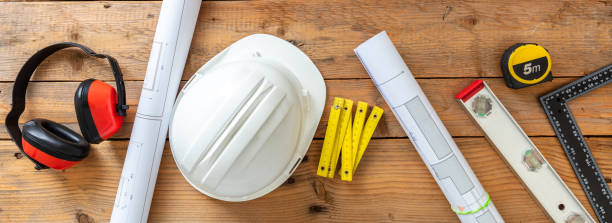 istock Architect engineer office desk, construction building drawings and equipment on a wooden table. 1352515458