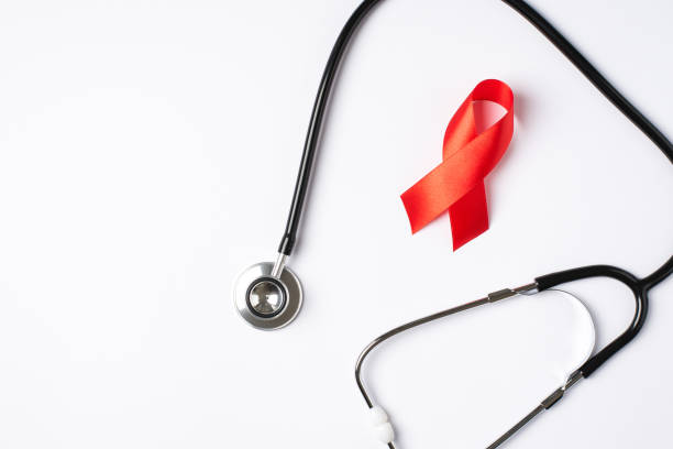 foto della vista dall'alto dello stetoscopio e del simbolo del nastro di seta rosso della consapevolezza dell'aids su sfondo bianco isolato con copyspace - aids foto e immagini stock