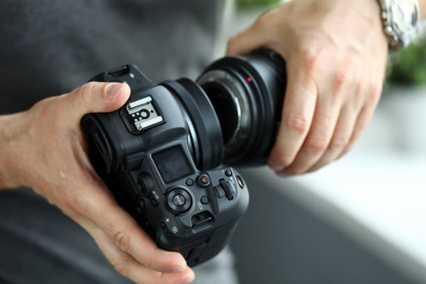 istock Male hands putting on modern digital camera professional lens 1352515713