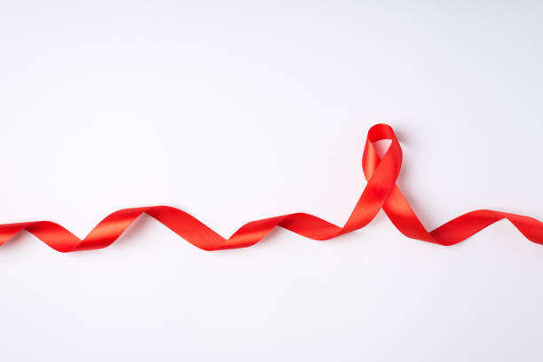 카피 스페이스와 고립 된 흰색 배경에 대한 인식을 돕는 곱슬 빨간 실크 리본 기호의 상단 보기 사진 - aids awareness ribbon 뉴스 사진 이미지