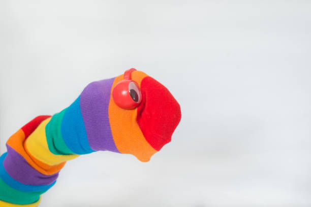 istock Hand puppet for LGBTQ+ rights. Rainbow flag sock and red eyes. White background. 1352516911