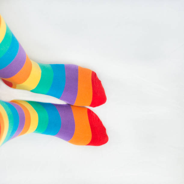 istock LGBTG+ rights. Two left feet wearing rainbow flag socks, with white background 1352516917