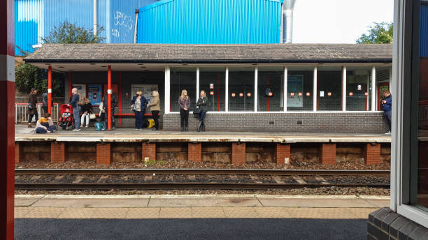 People wait for the train in the platform of Pudsey train station. Pudsy, United Kingdom - October 3, 2021: People wait for the train in the platform of Pudsey train station. named animal stock pictures, royalty-free photos & images