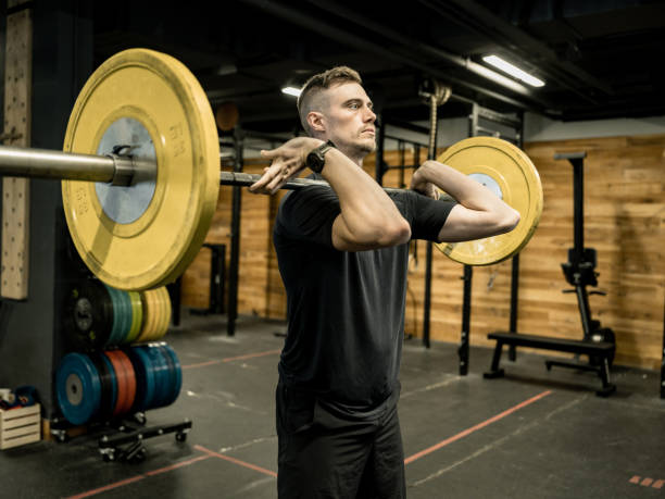 istock Young Man lifting weights in the Gym 1352520818
