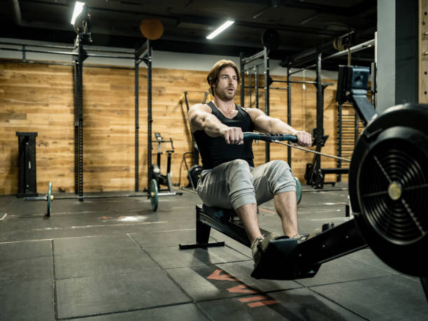 istock Young man exercising on rowing machine in the Gym 1352520954
