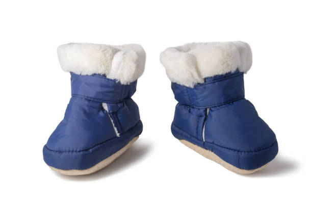 botas de invierno para bebés con pelaje aislado sobre fondo blanco. nuevas botas azules esponjosas para niño o niña recién nacido - bota de la nieve fotografías e imágenes de stock