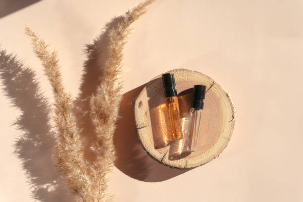 dos probadores de perfumes con líquido transparente sobre una xilografía con hierba de pampa sobre fondo beige - musk fotografías e imágenes de stock