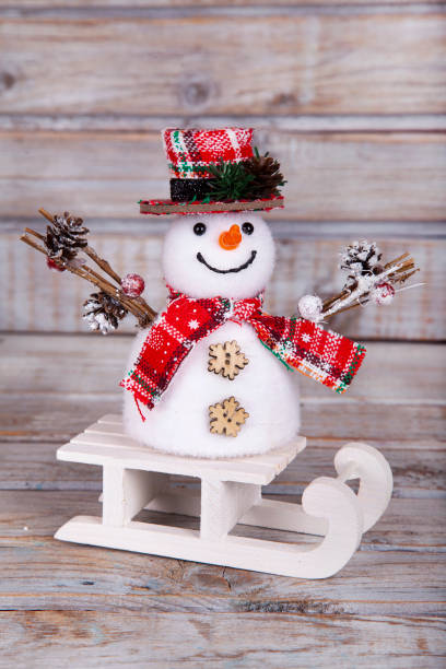 Christmas decorative snowman on white rustic wooden background.