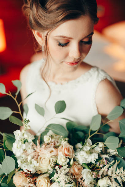 hermosa novia con un vestido de encaje blanco con un ramo de flores en la habitación. retrato - bridal portrait fotografías e imágenes de stock