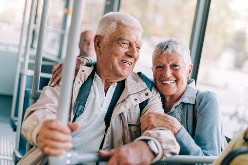 Smiling mature couple traveling by bus.