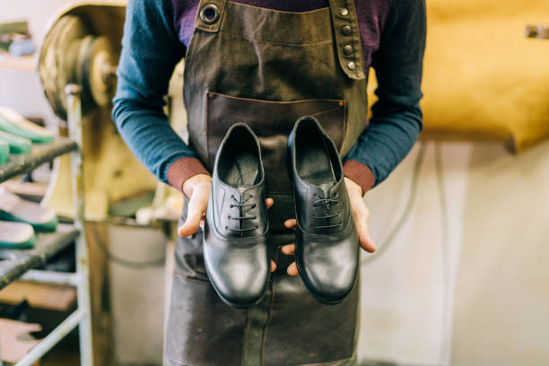 istock Shoe maker in workshop showing luxury handmade shoes. 1352526120