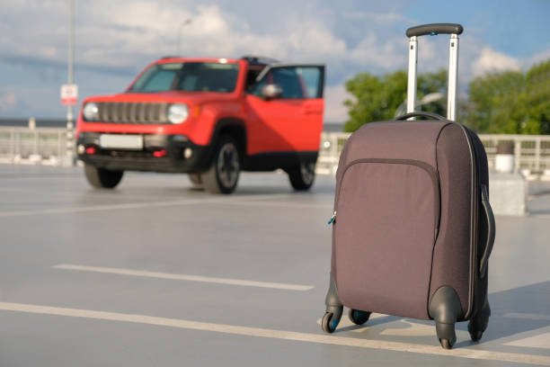 istock Suitcase in a car park outdoors. Travel, vacation concept 1352527388