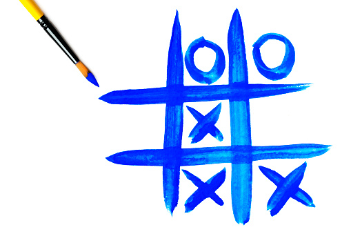 Close-up of a paintbrush with a blue painted tic-tac-toe. Isolated on a white background. Space for copy.