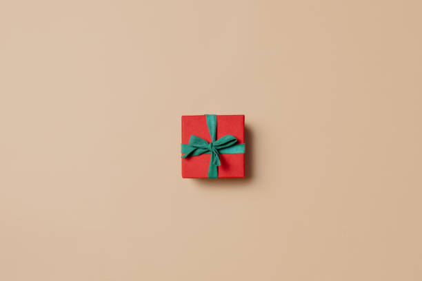 istock red gift box with green ribbon on stark white background. 1352531522