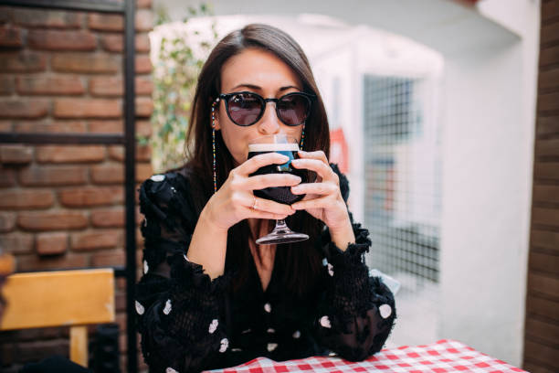 istock Woman drinking beer at outside brewery bar 1352531600