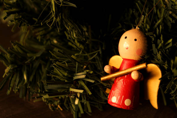 istock Christmas figurines hanging from pine tree branch 1352534244