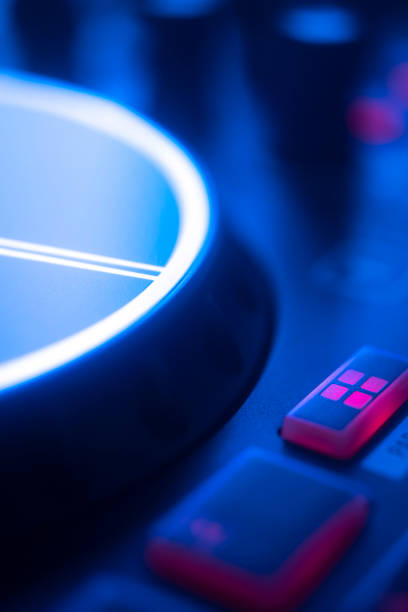 istock DJ mixing desk turntable in colored wedding disco party lights. 1352535476