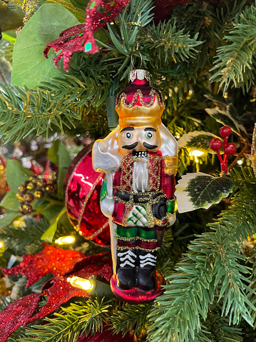Traditional Christmas nutcracker wooden figure. Beautiful, festive toy soldier, winter holiday season decoration, with tree lights bokeh in background.