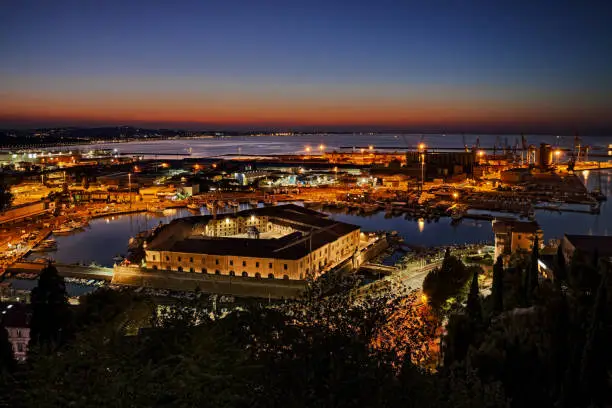Ancona, Marche, Italy: night landscape of the sheltered port for the small boats and fishing vessels with the pentagonal Mole Vanvitelliana, built on 18th-century as a lazzaretto quarantine station