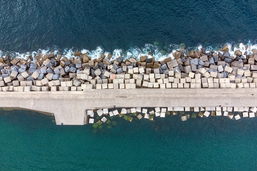 Aerial Drone Flying, Breakwater Of Stone In The Sea. High quality photo.