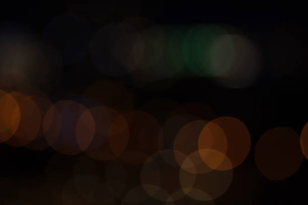 istock Defocused bokeh lights on black background, an abstract naturally blurred backdrop 1352542184