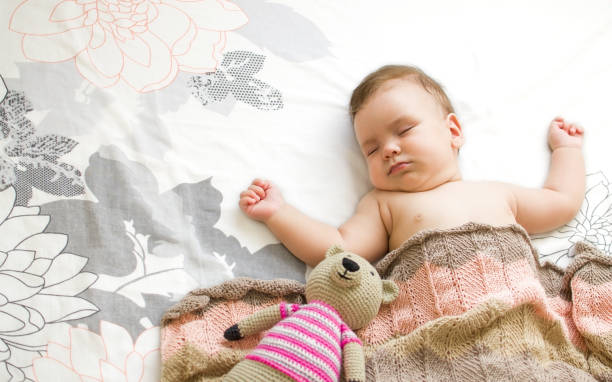 istock The baby sleeps, together with a teddy bear 1352545748