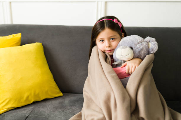 Adorable girl feeling cold at home It's so chilly outside. Beautiful child hugging her teddy bear and feeling cozy under a blanket while relaxing during winter hot mexican girls stock pictures, royalty-free photos & images
