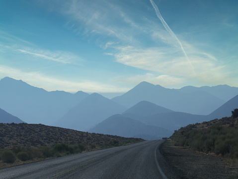 Rugged road with distant mountains in the background in Kern County, California.
