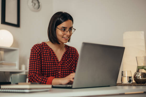 istock Beautiful woman using a laptop while working from home 1352554029