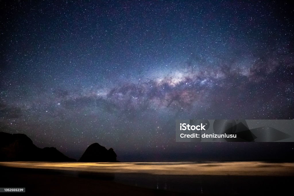 Piha Beach and Milky Way Galaxy at night in Auckland, New Zealand Blue Stock Photo