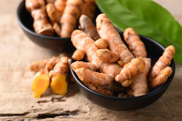 istock Fresh turmeric in a bowl on wooden background 1352556115