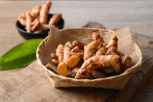 istock Fresh turmeric in a basket on wooden background 1352556180