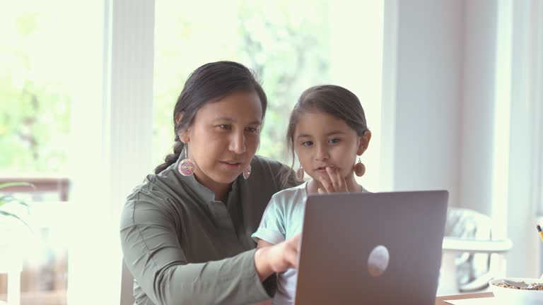 Mom and daughter using laptop computer