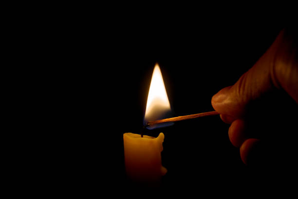 istock Burning candle in the darkness. Lighting candle with match. 1352563029