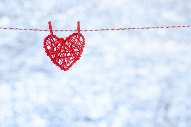 밧줄에 매달려 있는 빨간 심장. 그것은 모든 주위에 �눈이 내리고 있습니다. 흐릿한 반짝이는 흰색 을 배경으로. 공간을 복사합니다. 개념 - love hanging indoors studio shot 뉴스 사진 이미지