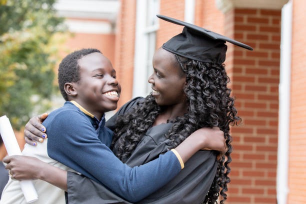 istock Mother wearing cap and gown hugging Son after Graduation ceremony 1352575984