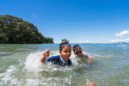 Happy brothers relaxing and playing in sea.