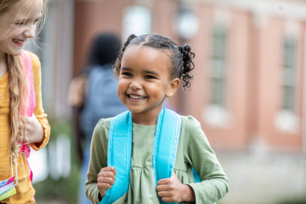 学校でお互いに話している小さな女の子 - child student adolescence cute ストックフォトと画像